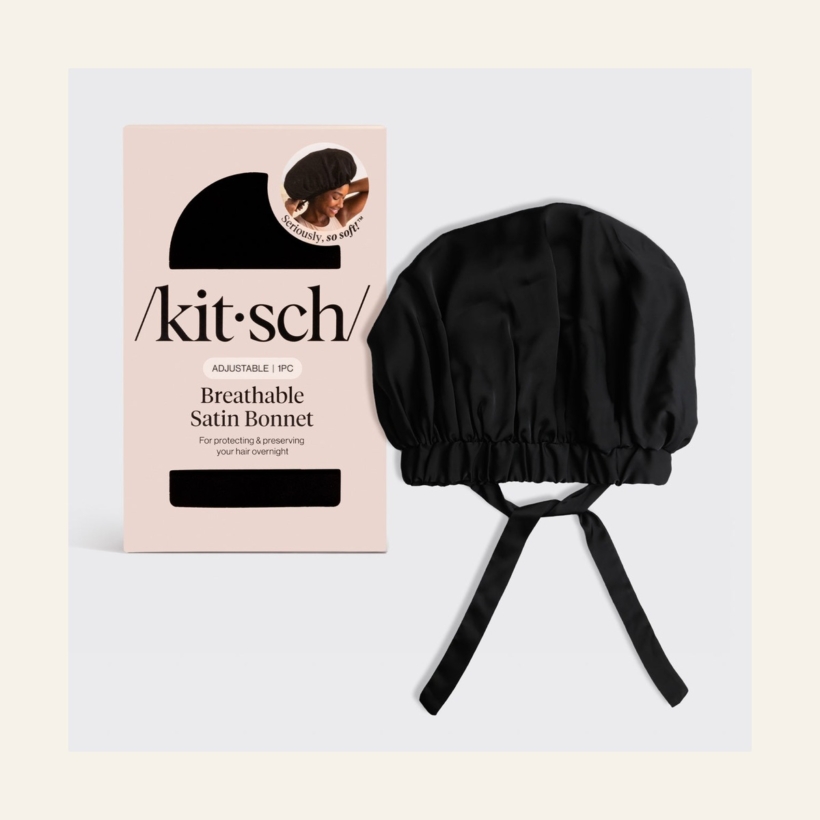Kitsch XL Satin Bonnet in Black with adjustable ties beside its retail packaging